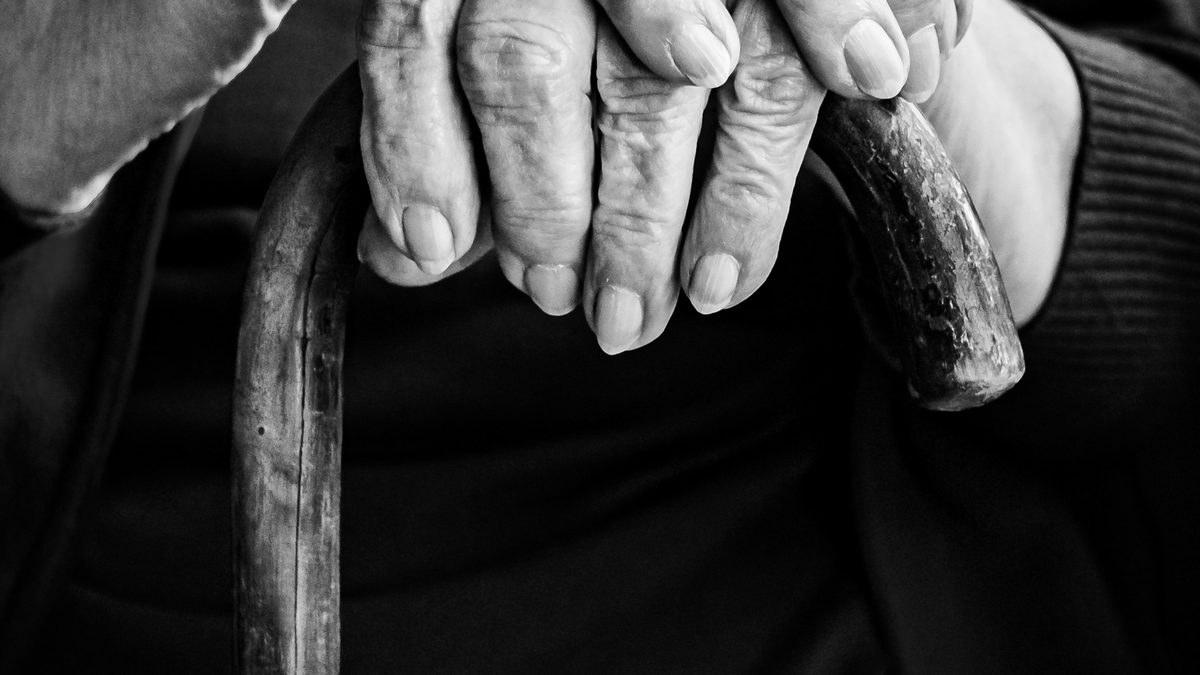 Hands resting on a cane.