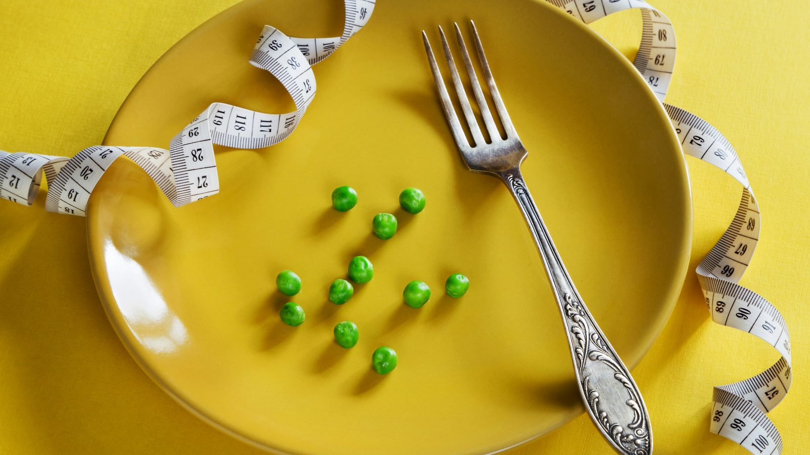 A plate and measuring tape representing weight management.