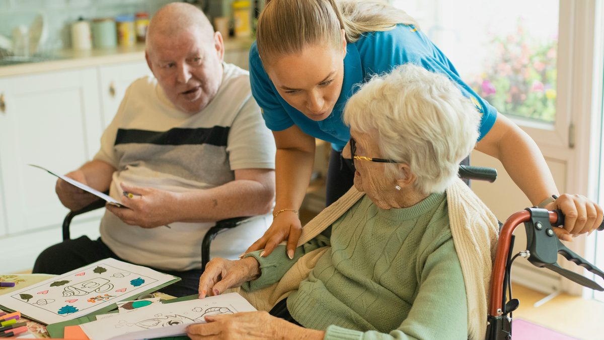 Caregiver helping older adults with an activity.